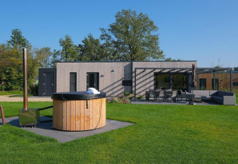 Villa vacacional Amalia 4 con jacuzzi en Hofparken Wiltershaar, Países Bajos, con terraza y césped.