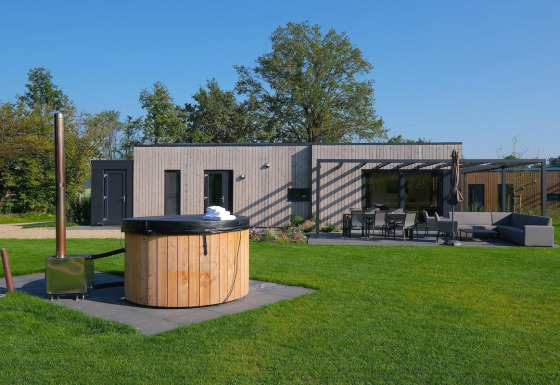 Holiday villa Amalia 4 plus hot tub at Hofparken Wiltershaar, Netherlands, showing patio and garden area.