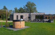 Holiday villa Amalia 4 plus hot tub at Hofparken Wiltershaar, Netherlands, showing patio and garden area.