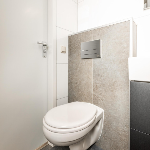 Moderno inodoro suspendido en el baño de la cabaña Biebosch en Resort Mooi Bemelen, Países Bajos.
