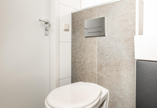 Moderno inodoro suspendido en el baño de la cabaña Biebosch en Resort Mooi Bemelen, Países Bajos.
