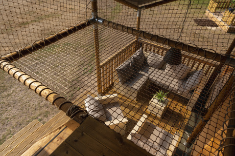 Top view of cozy seating with sofas and net in a safari tent at Wilsumer Berge in Germany.