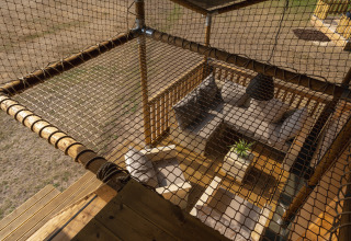 Top view of cozy seating with sofas and net in a safari tent at Wilsumer Berge in Germany.