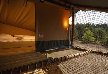 Tienda safari en Wilsumer Berge, Alemania, con cama cómoda y vistas al bosque para una experiencia glamping.