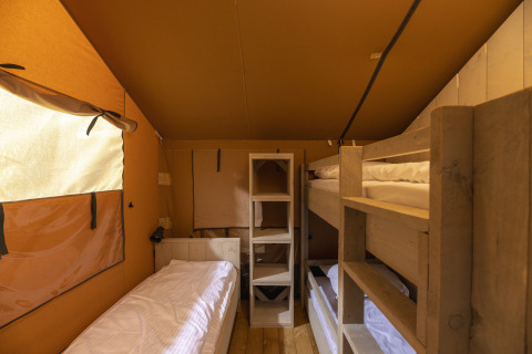 Interieur van de safaritent bij Wilsumer Berge in Duitsland met stapelbed en eenpersoonsbed.