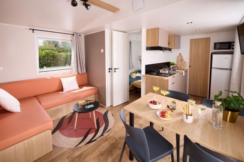 Gemütliches Wohnzimmer und Küche in einem Cottage bei Domaine Seasonova Saâne et Mer in Frankreich mit Esstisch.