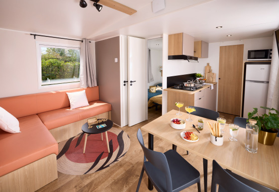Modern lounge and kitchen inside a cottage at Domaine Seasonova Saâne et Mer in France with a dining table.