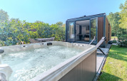 Jacuzzi exterior y tumbonas junto a la Forest Cabin en Holiday Park BreeBronne, Países Bajos.