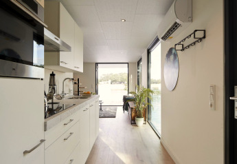 Moderne køkken og gang i Water Cube-lodge ved Holiday Park BreeBronne, Holland, med udsigt til vand.