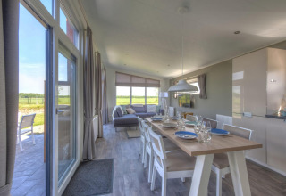 Salle à manger et salon lumineux du lodge Pavilion à Poort van Zeeland, vue sur le paysage néerlandais.
