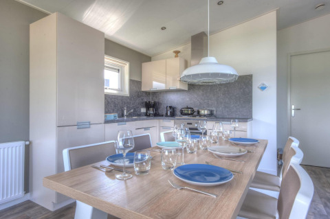 Coin repas et cuisine moderne d’un pavillon à Poort van Zeeland, Pays-Bas, table dressée pour six personnes.