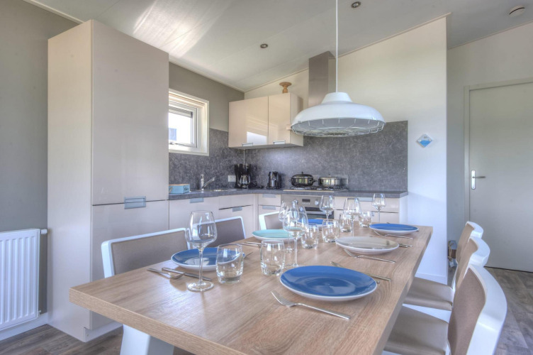 Comedor y cocina moderna en una cabaña del Pavilion en Poort van Zeeland, Países Bajos, mesa para seis.