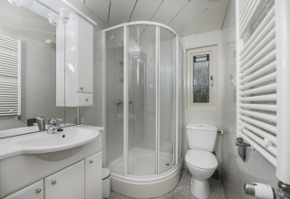 Salle de bain moderne avec douche, toilettes et lavabo à Nature Lodge, Bospark Markelo, Pays-Bas.