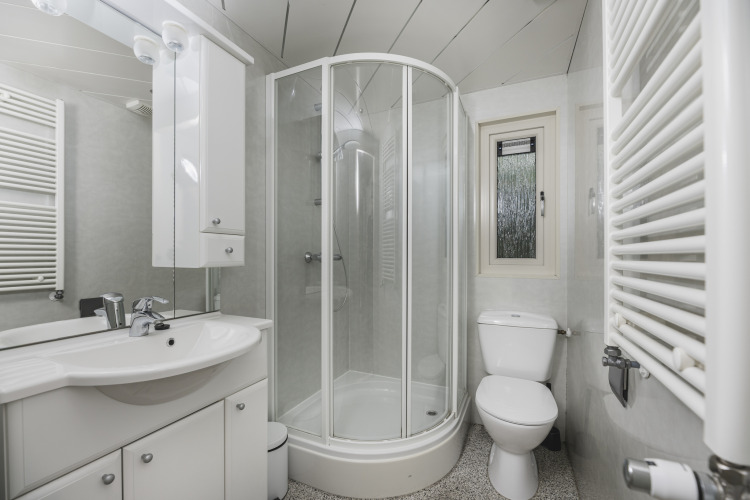 Salle de bain moderne avec douche, toilettes et lavabo à Nature Lodge, Bospark Markelo, Pays-Bas.