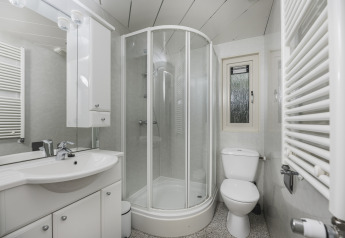 Moderne badeværelse med bruseniche, toilet og vask på Nature lodge i Bospark Markelo, Holland.