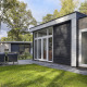 Moderne tiny house in Bospark Markelo, Nederland, met terras, tuinmeubilair en omringd door groen.