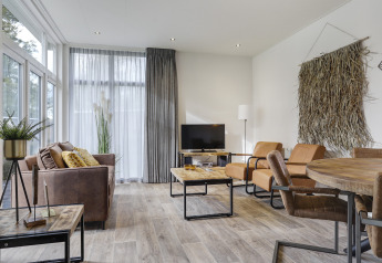 Sala moderna de una Tiny House en Bospark Markelo, Países Bajos, con decoración rústica y muebles cómodos.