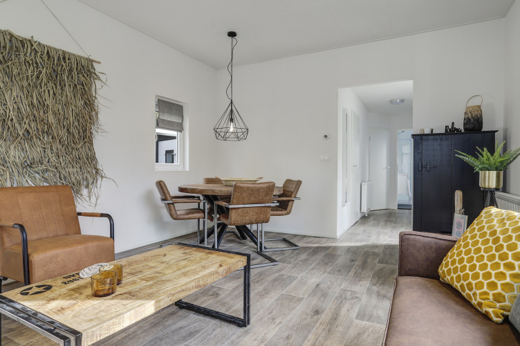 Modern eingerichtetes Tiny House im Bospark Markelo, Niederlande, mit Holzfußboden und gemütlichem Wohnzimmer.