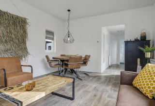 Soggiorno di una tiny house moderna al Bospark Markelo nei Paesi Bassi con arredi e dettagli in legno.