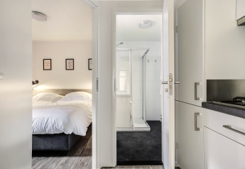 Chambre, salle de bain et cuisine dans un Tiny House au Bospark Markelo, Pays-Bas, au décor moderne.