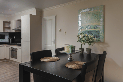 Zona de comedor moderna y cocina en Forest Lodge Wellness, Bospark Markelo, Países Bajos, con decoración elegante.