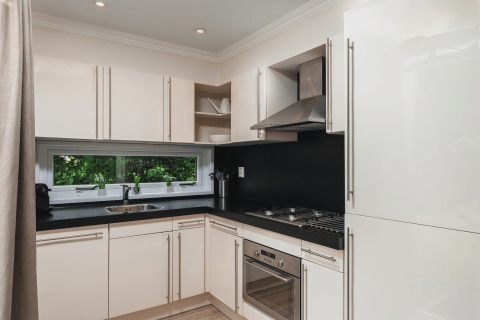 Moderne, lichte keuken met witte kasten in Forest Lodge Wellness op Bospark Markelo in Nederland.