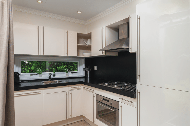 Cocina moderna y luminosa con gabinetes blancos en Forest Lodge Wellness en Bospark Markelo, Países Bajos.