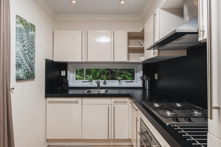 Cocina moderna y compacta en Forest Lodge Wellness, Bospark Markelo, Países Bajos, con gabinetes blancos.