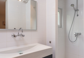 Kompaktes modernes Badezimmer mit Dusche, Spiegel und Waschtisch im Forest Lodge Wellness, Bospark Markelo.