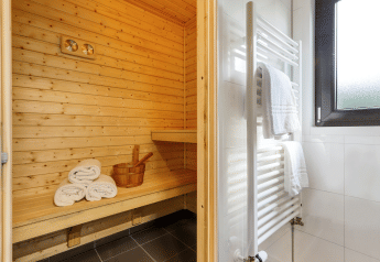 Veludstyret sauna og badeværelse i Forest Lodge Wellness, Bospark Markelo, Holland, med træinteriør.