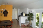 Interieur van Lodge Meerkoet in Bospark Markelo, Nederland, met eethoek, keuken en gele accentmuur.