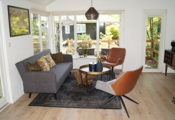 Lichte woonkamer in Lodge Meerkoet op Bospark Markelo, Nederland, met moderne inrichting en uitzicht op de tuin.