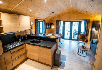 Interni in legno moderni al Terrace Chalet di Bospark Markelo, Paesi Bassi, con cucina e soggiorno aperti.
