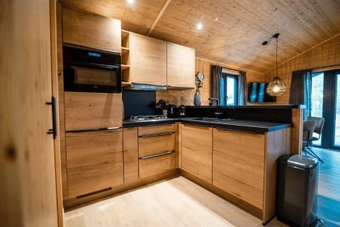 Moderna cucina in legno nel Terrace Chalet al Bospark Markelo, Paesi Bassi, con elettrodomestici eleganti.