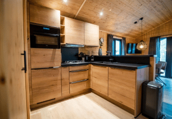 Moderna cucina in legno nel Terrace Chalet al Bospark Markelo, Paesi Bassi, con elettrodomestici eleganti.