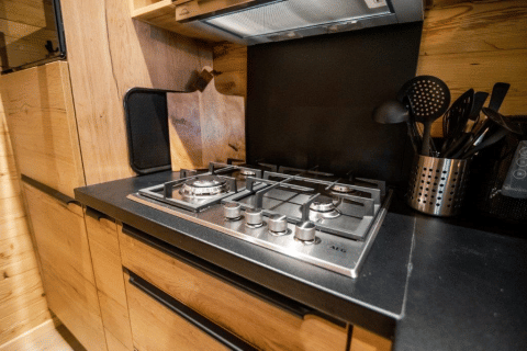 Moderne Gaskochfeld und Küchenutensilien in einem Holzchalet auf dem Bospark Markelo in den Niederlanden.