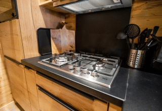 Moderne Gaskochfeld und Küchenutensilien in einem Holzchalet auf dem Bospark Markelo in den Niederlanden.
