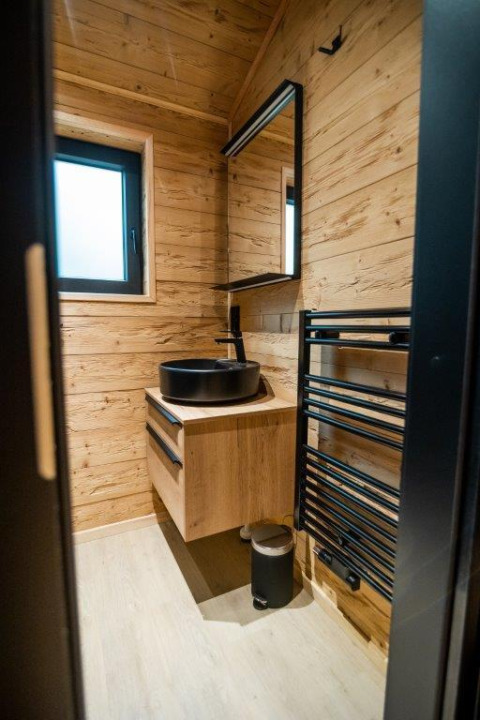 Baño moderno de madera en Terrace Chalet, Bospark Markelo, Países Bajos, con lavabo negro y espejo