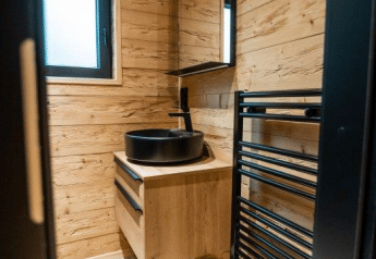 Modernes Bad mit Holzverkleidung in der Terrace Chalet im Bospark Markelo, Niederlande, mit schwarzem Waschbecken