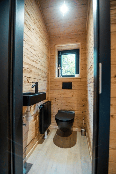 Bagno moderno con rubinetteria nera e pareti in legno presso Terrace Chalet al Bospark Markelo, Paesi Bassi.