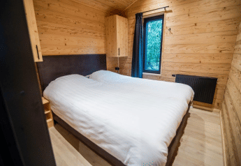 Camera da letto con pareti in legno e due letti singoli al Terrace Chalet, Bospark Markelo, Paesi Bassi.
