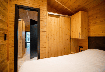 Schlafzimmer im Holzstil mit Schränken im Terrace Chalet, Bospark Markelo, Niederlande, moderne Einrichtung.