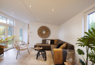 Moderne woonkamer in de Cubus Lodge van Bospark Markelo, Nederland, met gezellige sfeer en veel daglicht.