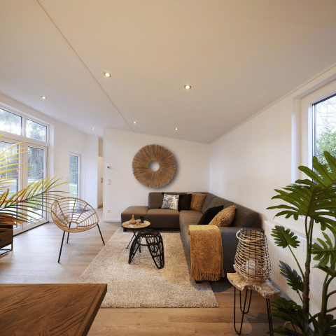 Moderne woonkamer in Cubus Lodge van Bospark Markelo, Nederland, met warme inrichting, planten en veel licht.