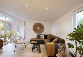 Modernes Wohnzimmer in der Cubus Lodge im Bospark Markelo, Niederlande, mit stilvoller Einrichtung und Pflanzen.