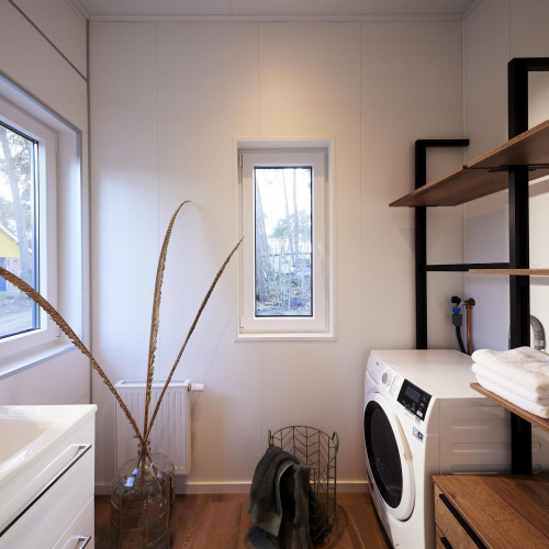 Modernes Waschzimmer in der Cubus Lodge, Bospark Markelo, Niederlande, mit Waschmaschine und Regalen.