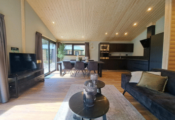 Moderne lodge met open keuken, zithoek en grote ramen bij Hackfort Wood Hottub 6 op de Utrechtse Heuvelrug.