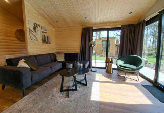 Modern lodge living room at Hackfort Wood Hottub 6, De Utrechtse Heuvelrug, Netherlands with wooden walls.