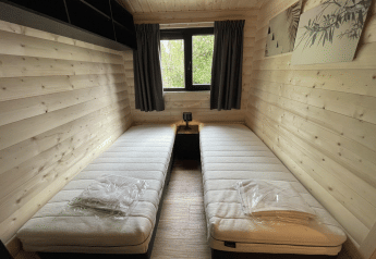 Twee eenpersoonsbedden in een gezellige houten kamer in Hackfort Wood Hottub 6, De Utrechtse Heuvelrug, Nederland.