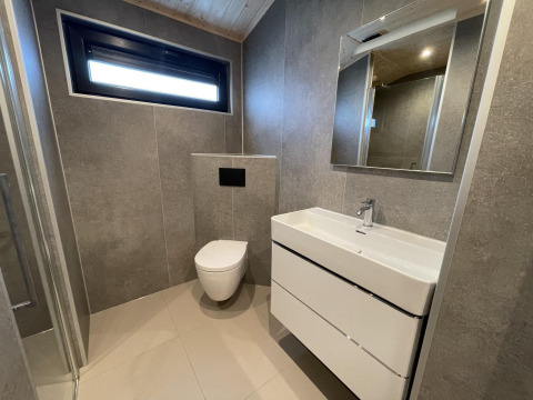 Bagno moderno in Hackfort Wood Hottub 6, De Utrechtse Heuvelrug, Paesi Bassi, con wc sospeso e lavabo.